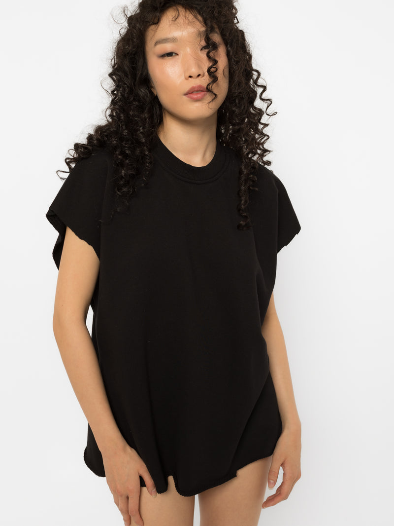 Black oversized t-shirt with raw cut edges worn with knee high boots