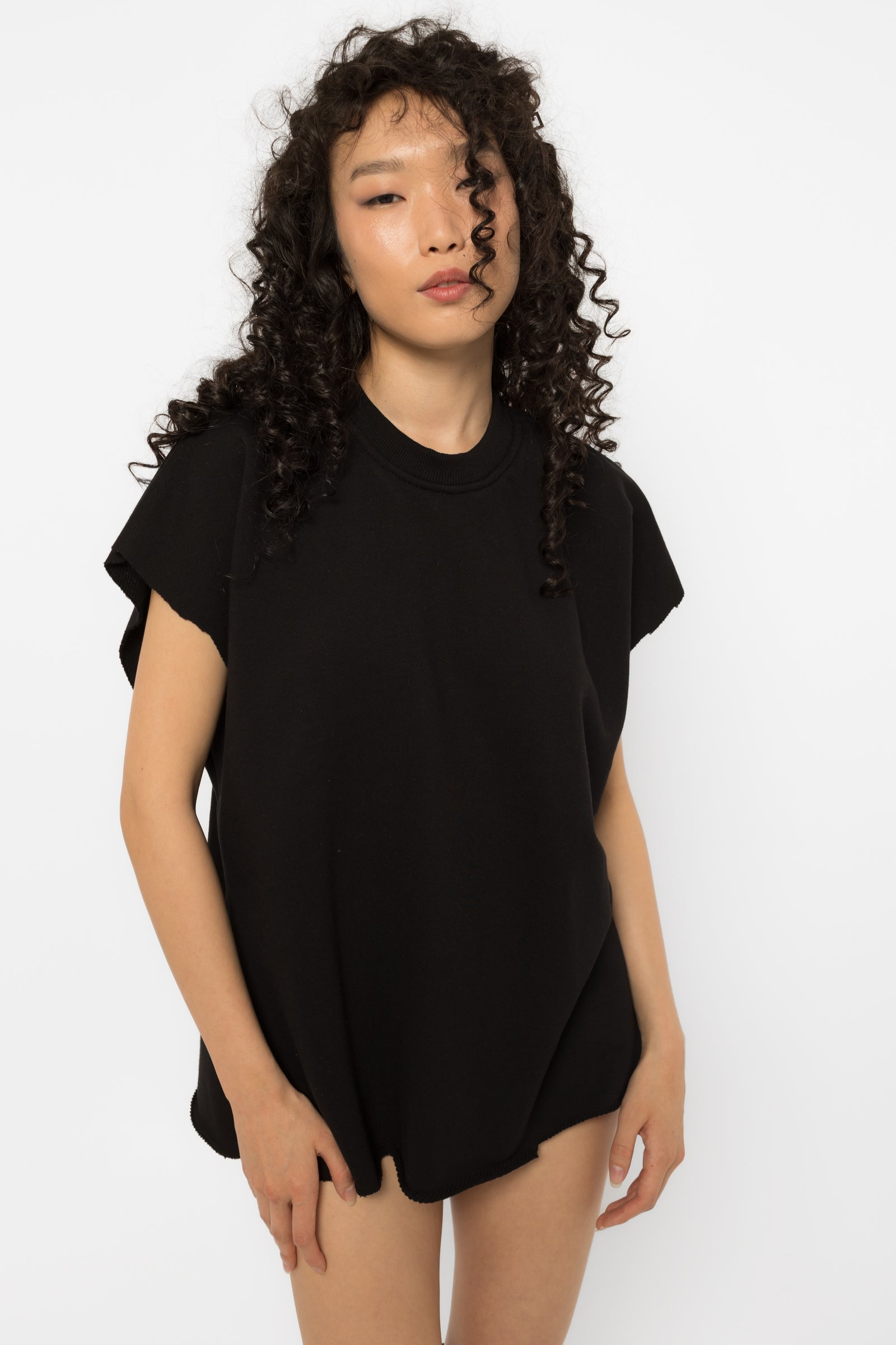 Black oversized t-shirt with raw cut edges worn with knee high boots
