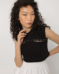 Chest cutout of the black crop top set with silver steel rings, close view
