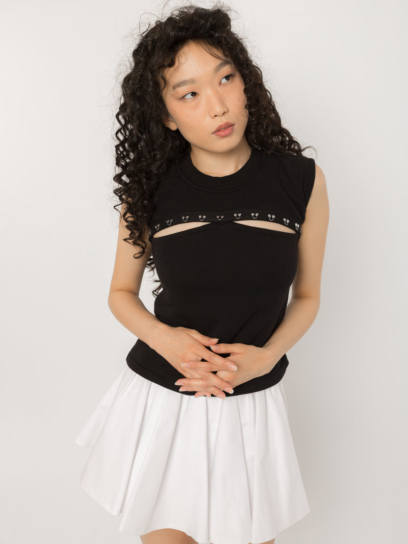 Model wearing Girl Code black pierced cutout sleeveless top, front view