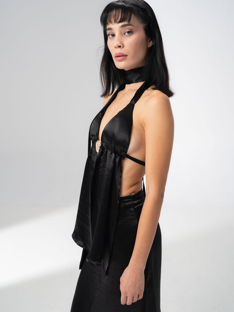 Open back of the black satin halter top tied with a long ribbon down the spine