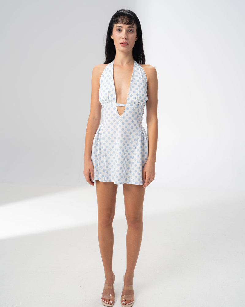 Model wearing the Girl Code blue polka dot halter dress with a deep plunging V neckline