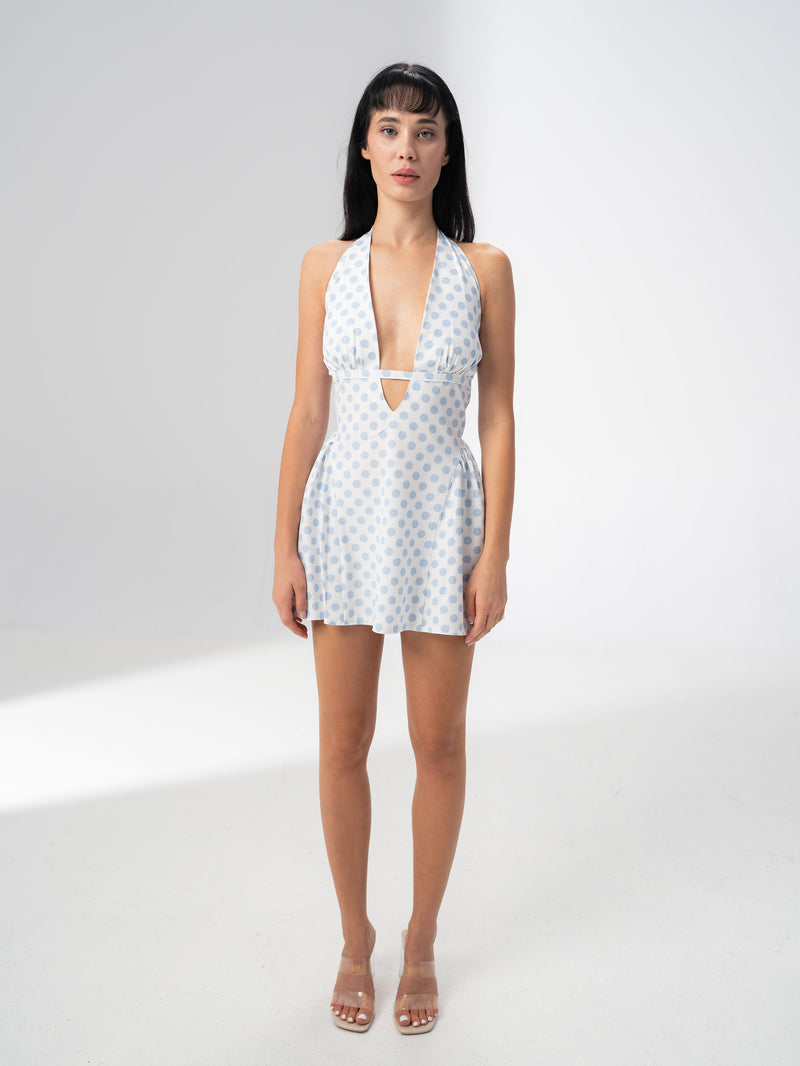 Model wearing the Girl Code blue polka dot halter dress with a deep plunging V neckline