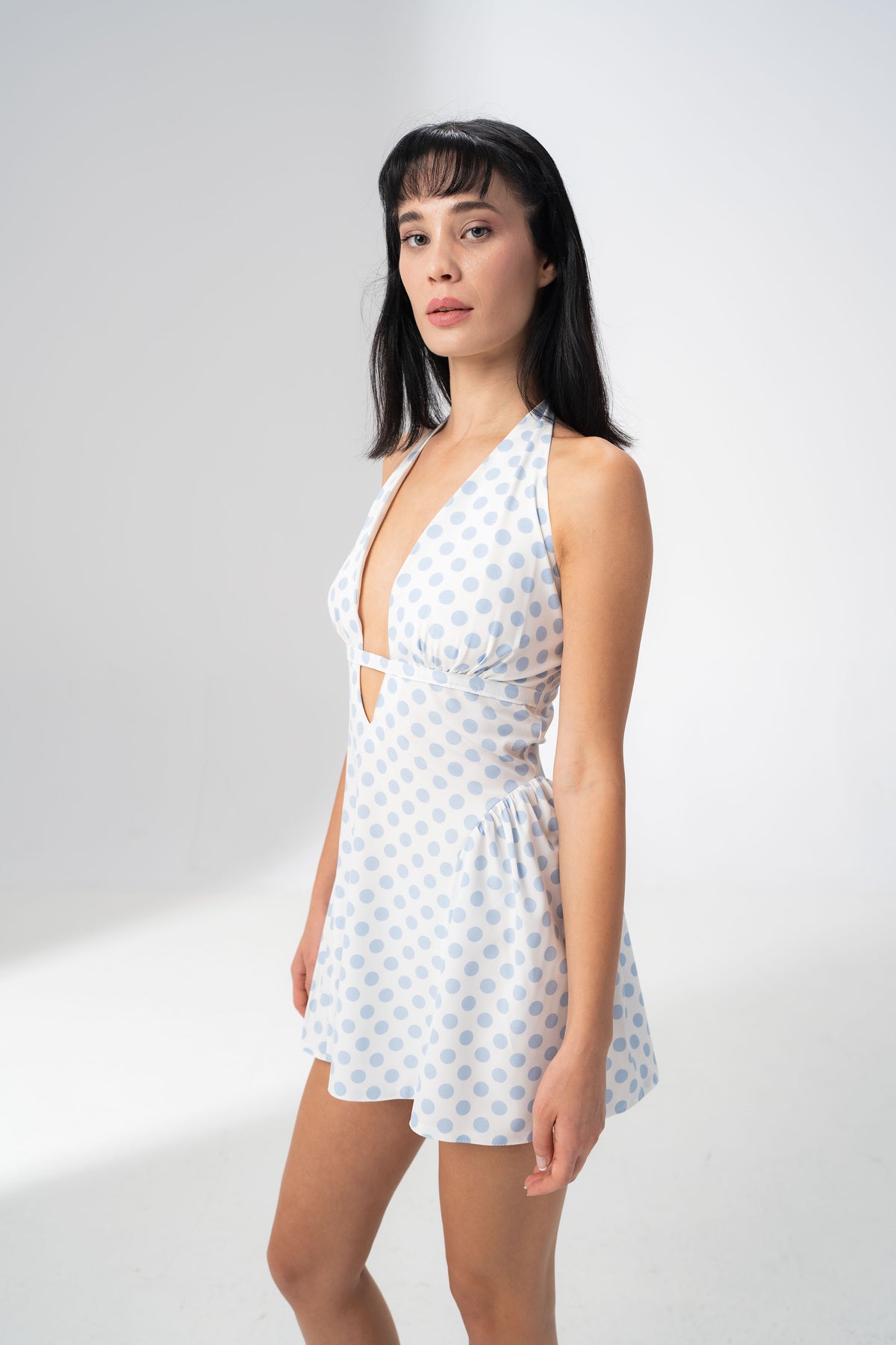 Side view of the Girl Code blue polka dot halter dress showing the fitted bodice and flared skirt