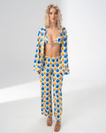 Model wearing the Girl Code blue and yellow satin three piece set with bralette, wide leg trousers and open shirt