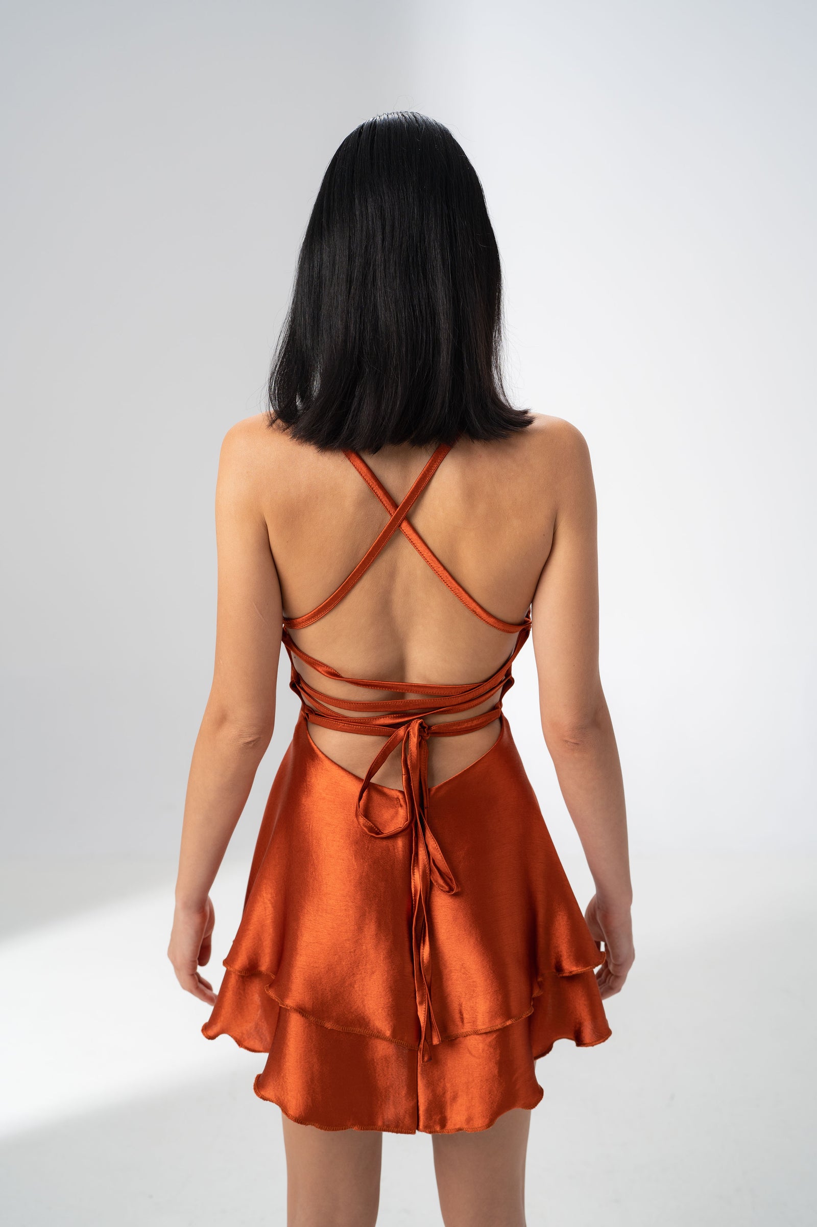 Girl Code burnt orange satin backless mini dress in a deep brick copper shade