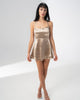 Model wearing the Girl Code champagne satin backless dress with fine straps and a ruffled skirt