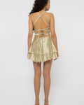 Open back of the champagne satin mini dress with crossed straps and waist bow