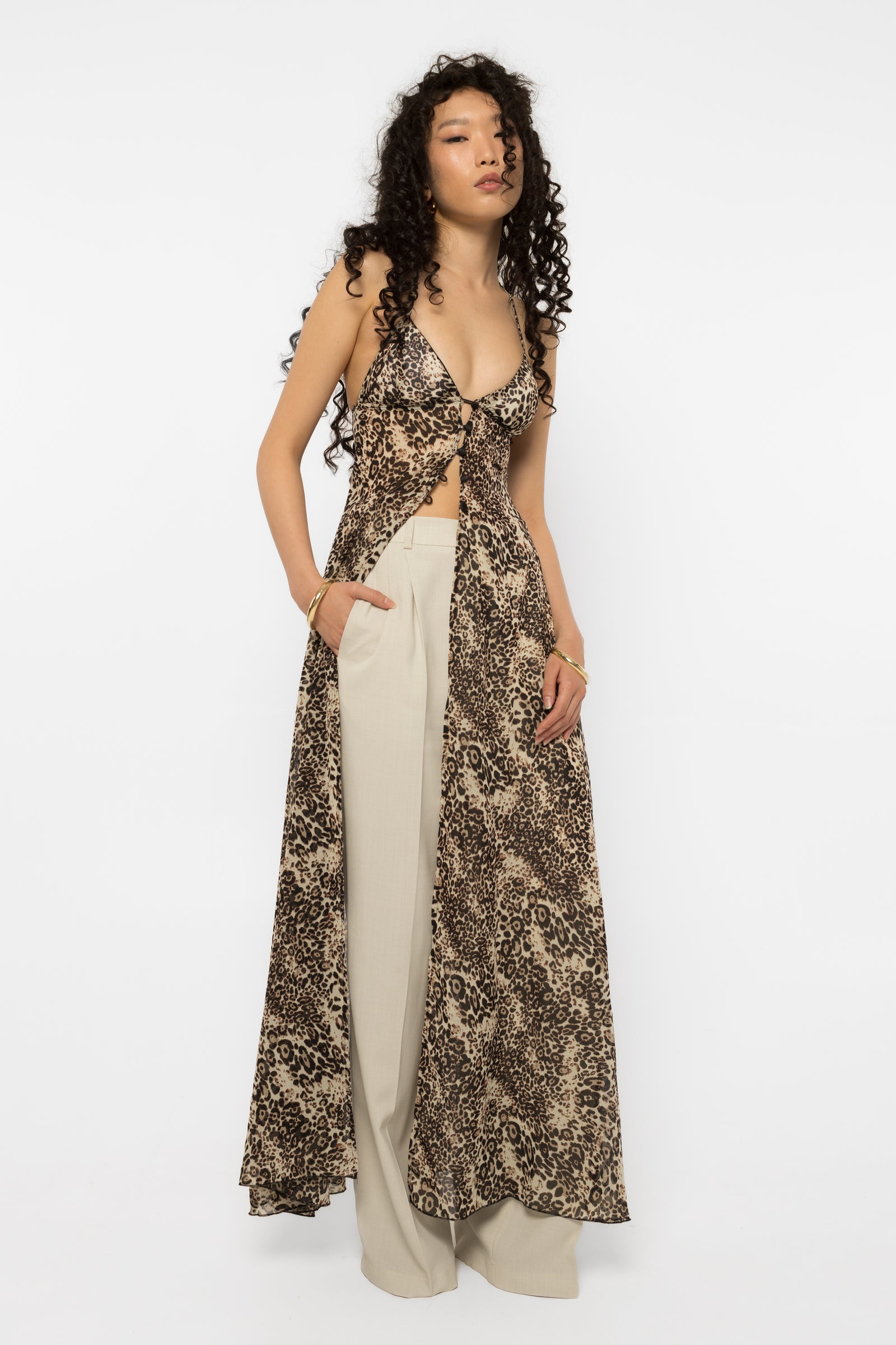 Model wearing Girl Code leopard print long shirt open over cream tailored trousers