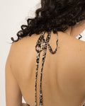 Self fabric halter ties knotted at the back neck of the leopard print long shirt