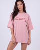 Model wearing Girl Code pink chain back slogan t-shirt, front view showing red printed text