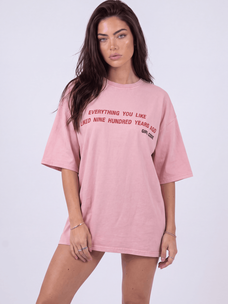 Model wearing Girl Code pink chain back slogan t-shirt, front view showing red printed text