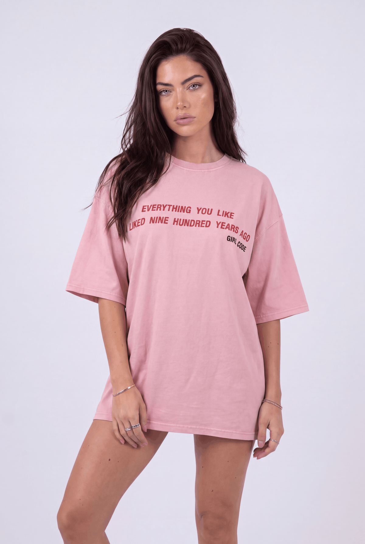 Model wearing Girl Code pink chain back slogan t-shirt, front view showing red printed text