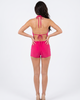 Model wearing Girl Code pink halter cowl romper, three quarter view showing cowl drape