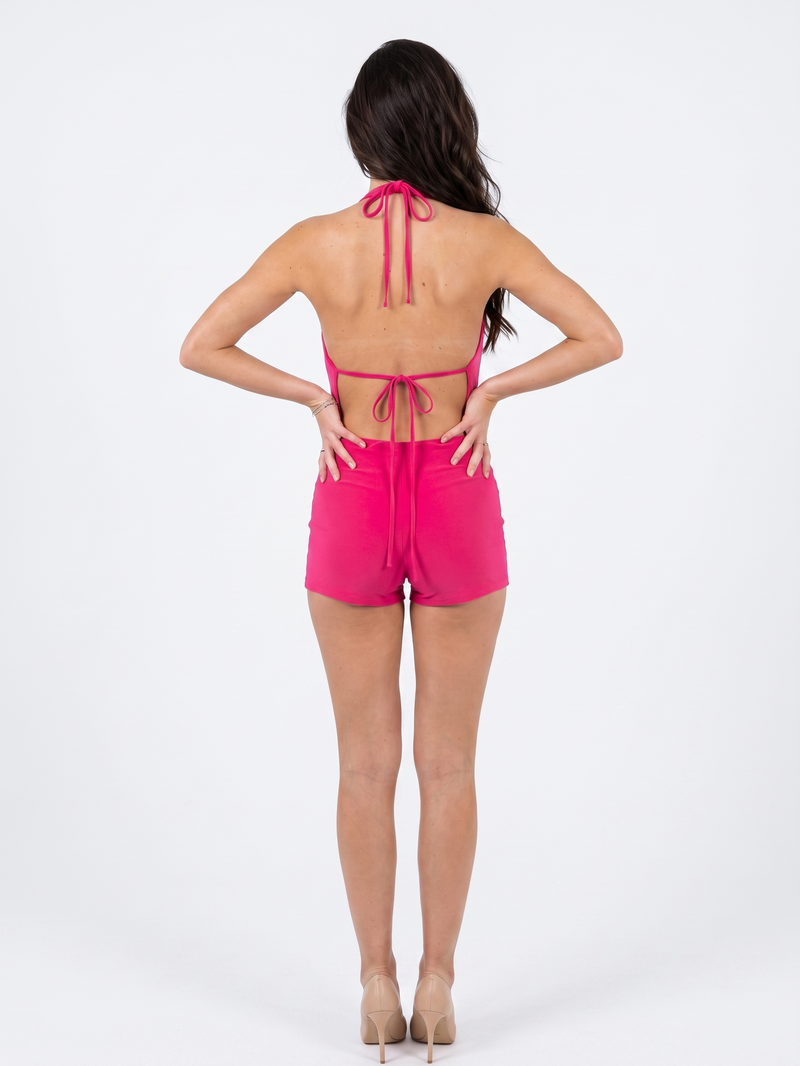 Model wearing Girl Code pink halter cowl romper, three quarter view showing cowl drape