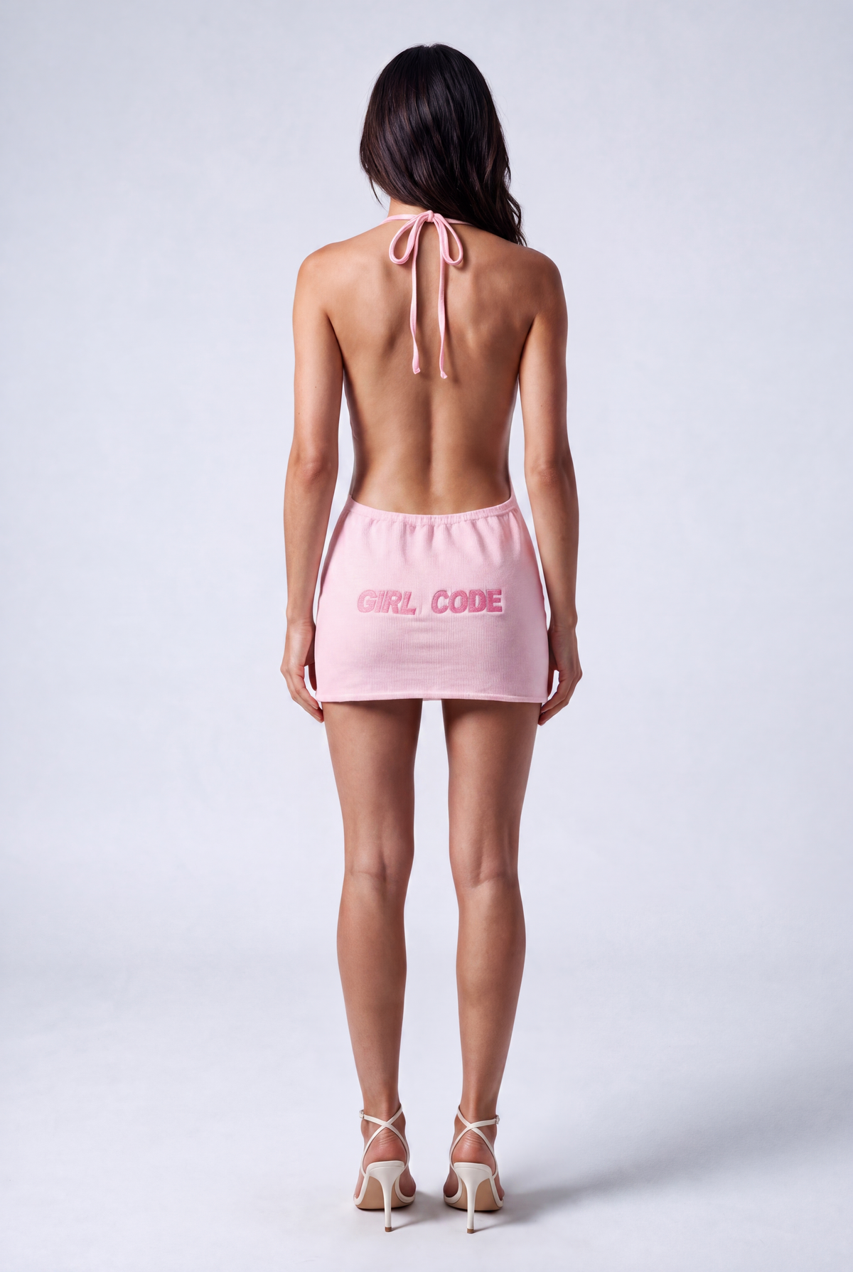Back view of the Girl Code pink ribbed halter mini dress showing fully open back and GIRL CODE pink logo print