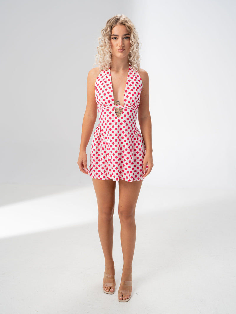 Model wearing the Girl Code polka dot halter mini dress with a deep plunging V neckline