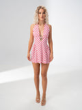 Model wearing the Girl Code polka dot halter mini dress with a deep plunging V neckline