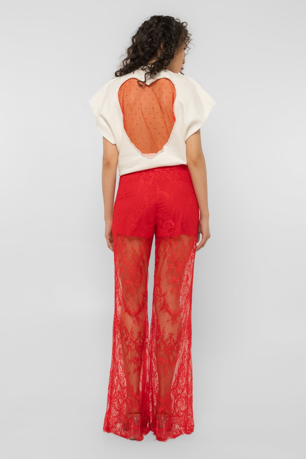 Side view of the Girl Code red lace-up palazzo pants showing the wide drape