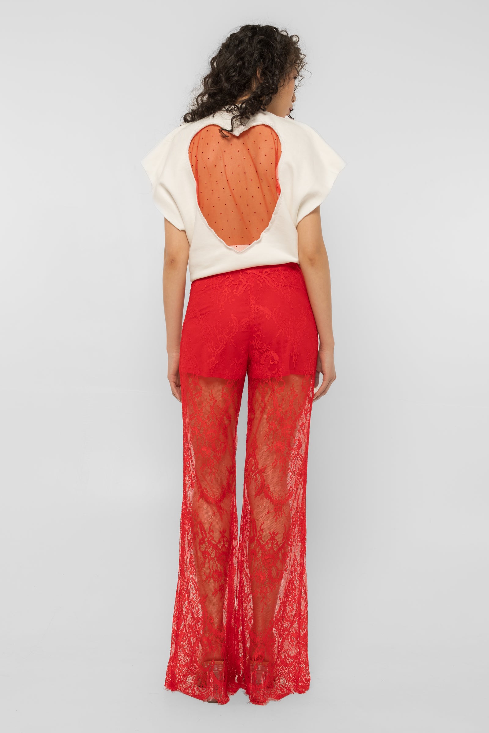 Side view of the Girl Code red lace-up palazzo pants showing the wide drape