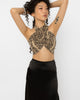 Model wearing Girl Code snake print wrap halter crop top with a black satin skirt
