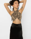 Model wearing Girl Code snake print wrap halter crop top with a black satin skirt