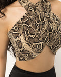 Snake print halter crop top with arms raised showing the open back and high neckline