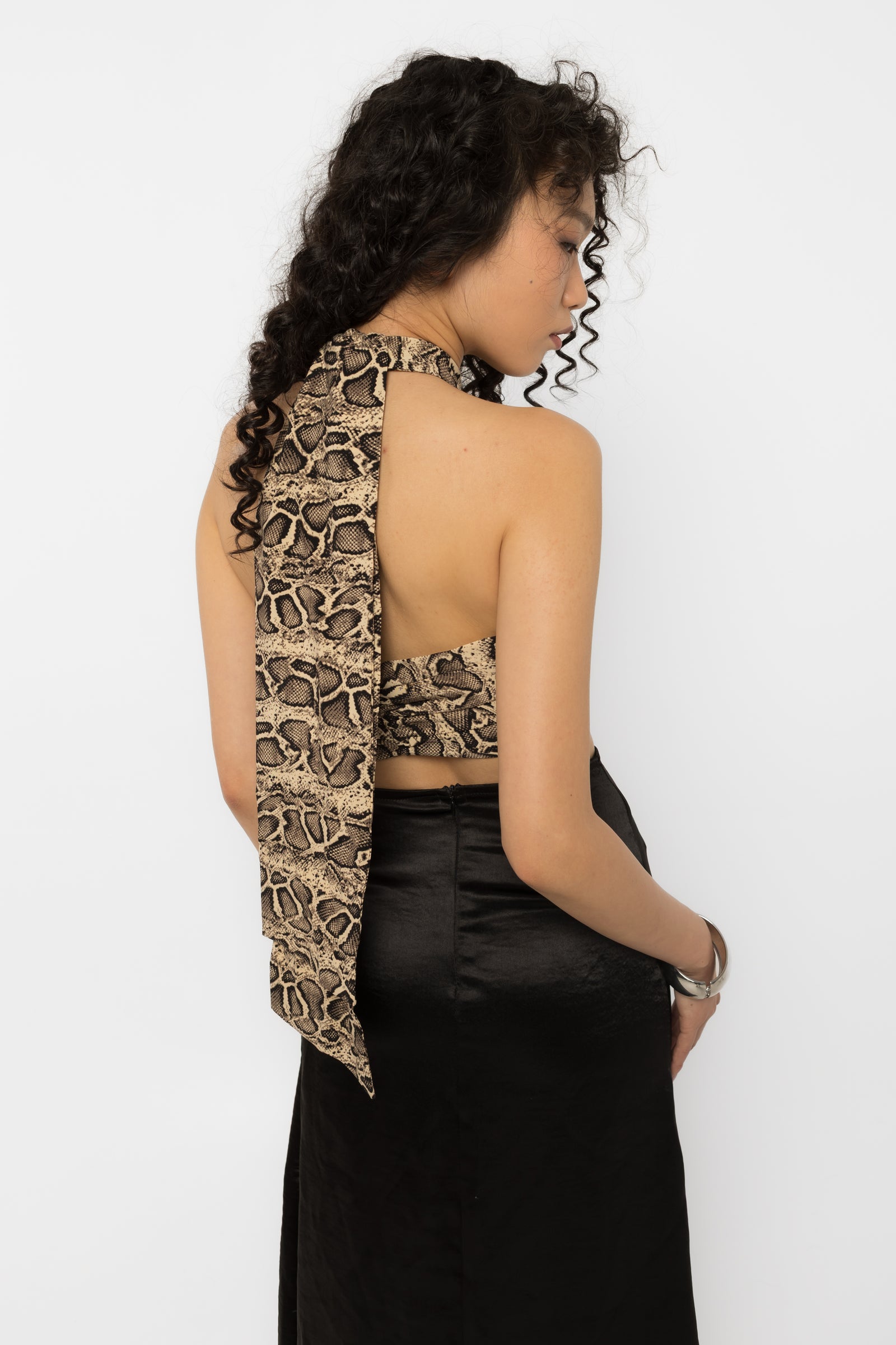 Close up of the beige brown and black snake print fabric on the halter crop top