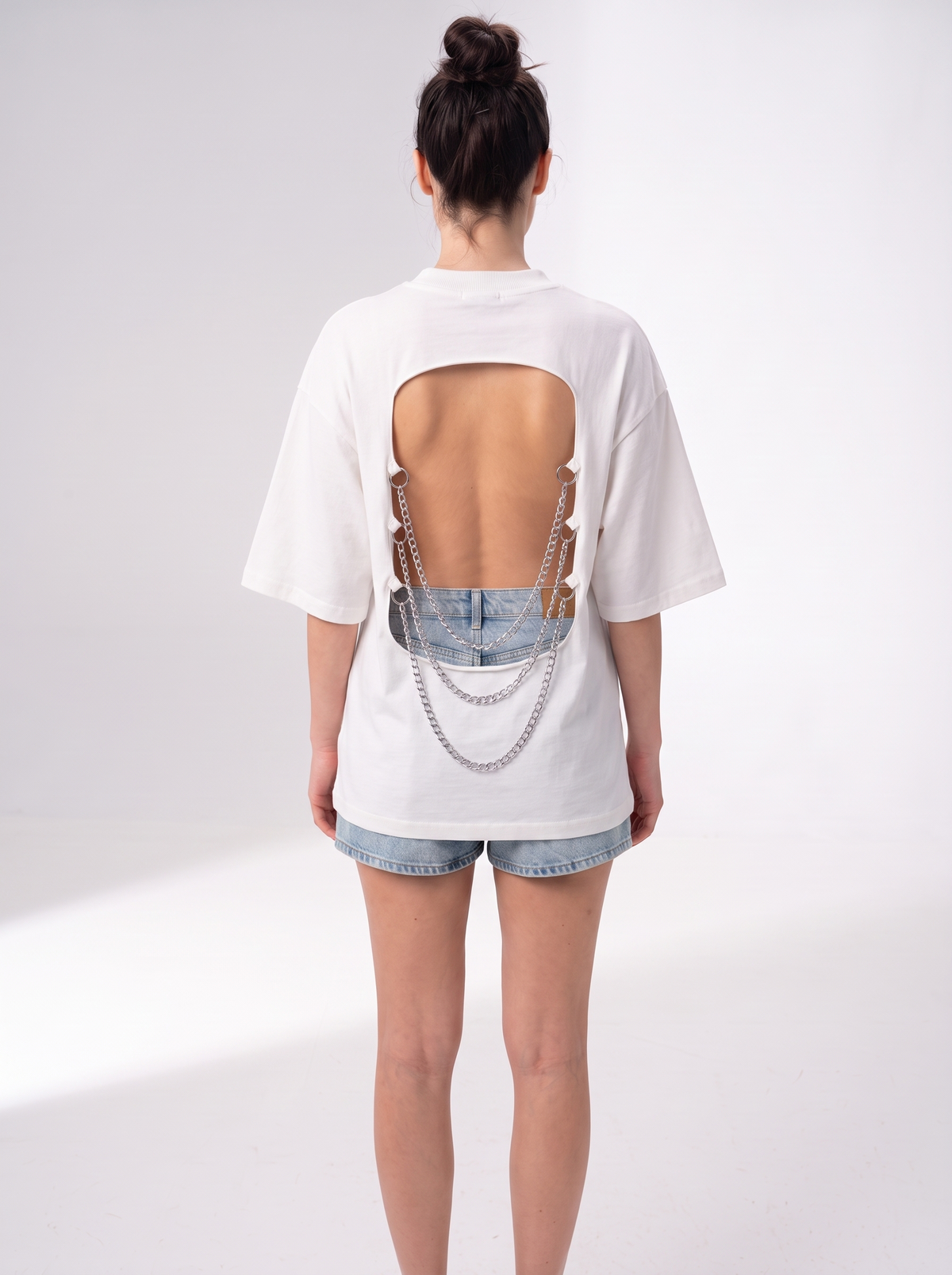 Back view of the Girl Code white chain back slogan t-shirt showing the open back cutout with silver chains