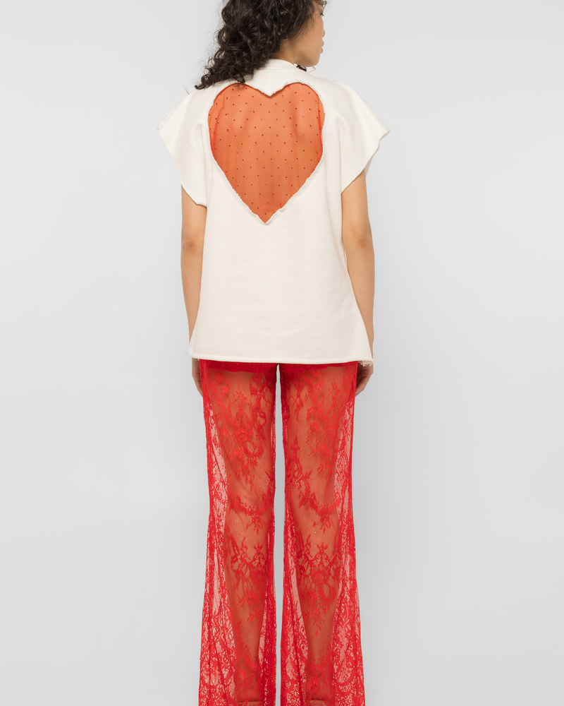 Model wearing Girl Code white heart cutout oversized t-shirt, back view showing red crystal tulle heart