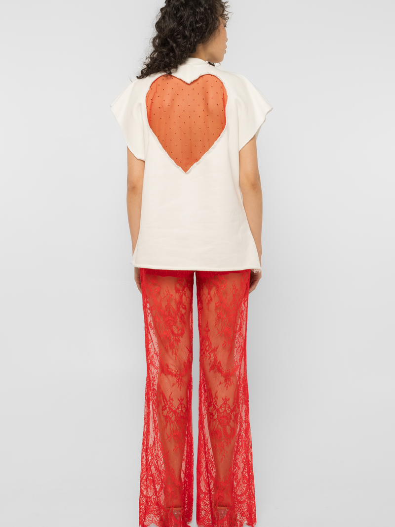 Model wearing Girl Code white heart cutout oversized t-shirt, back view showing red crystal tulle heart
