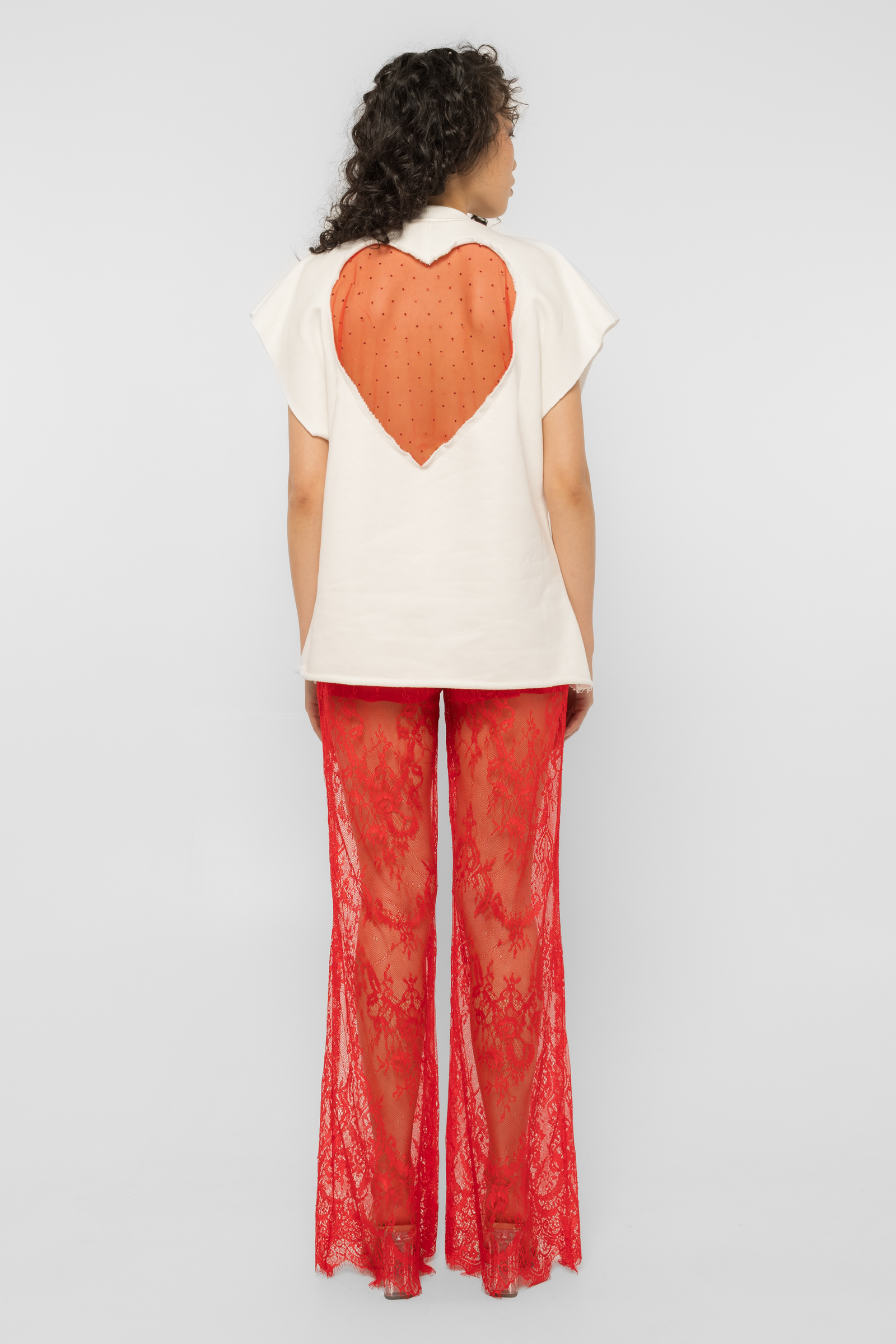Model wearing Girl Code white heart cutout oversized t-shirt, back view showing red crystal tulle heart