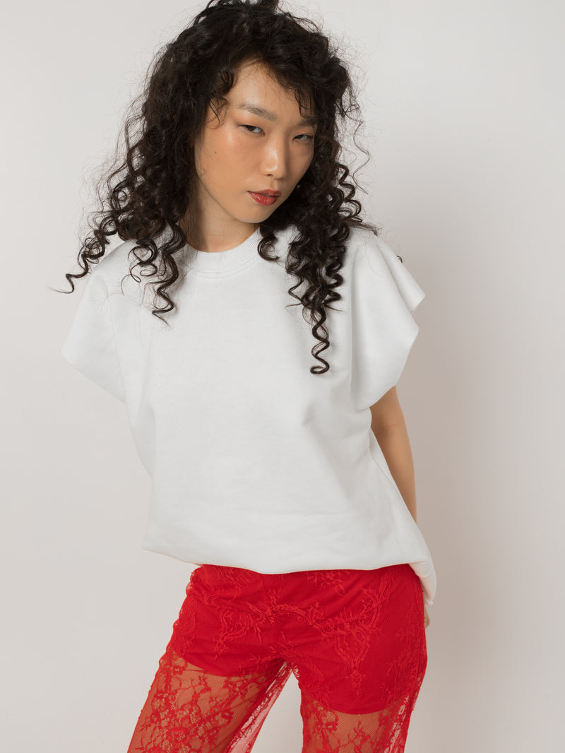Close up of red crystals set into the tulle heart on the white cotton tee