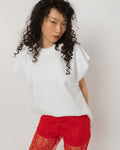 Close up of red crystals set into the tulle heart on the white cotton tee