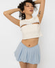 Model wearing Girl Code white pierced cutout crop top with steel rings