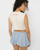 Chest cutout of the white crop top set with silver steel rings, close view
