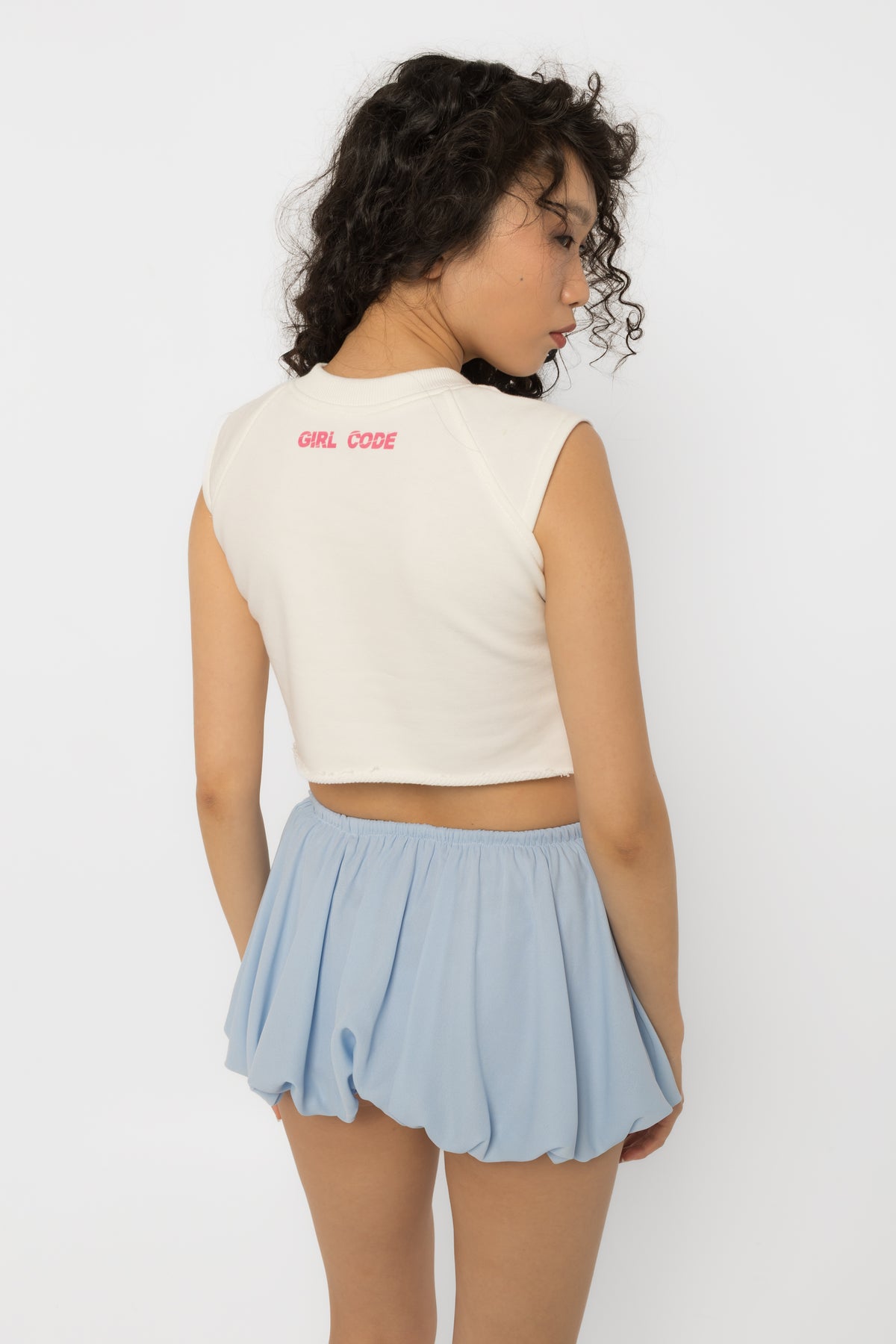 Chest cutout of the white crop top set with silver steel rings, close view